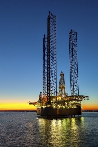 Offshore oil rig at sunset, representing hydraulic solutions for the oil and gas industry
