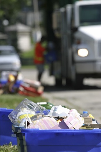 Recycling bins and a collection truck, representing hydraulic solutions for the recycling industry