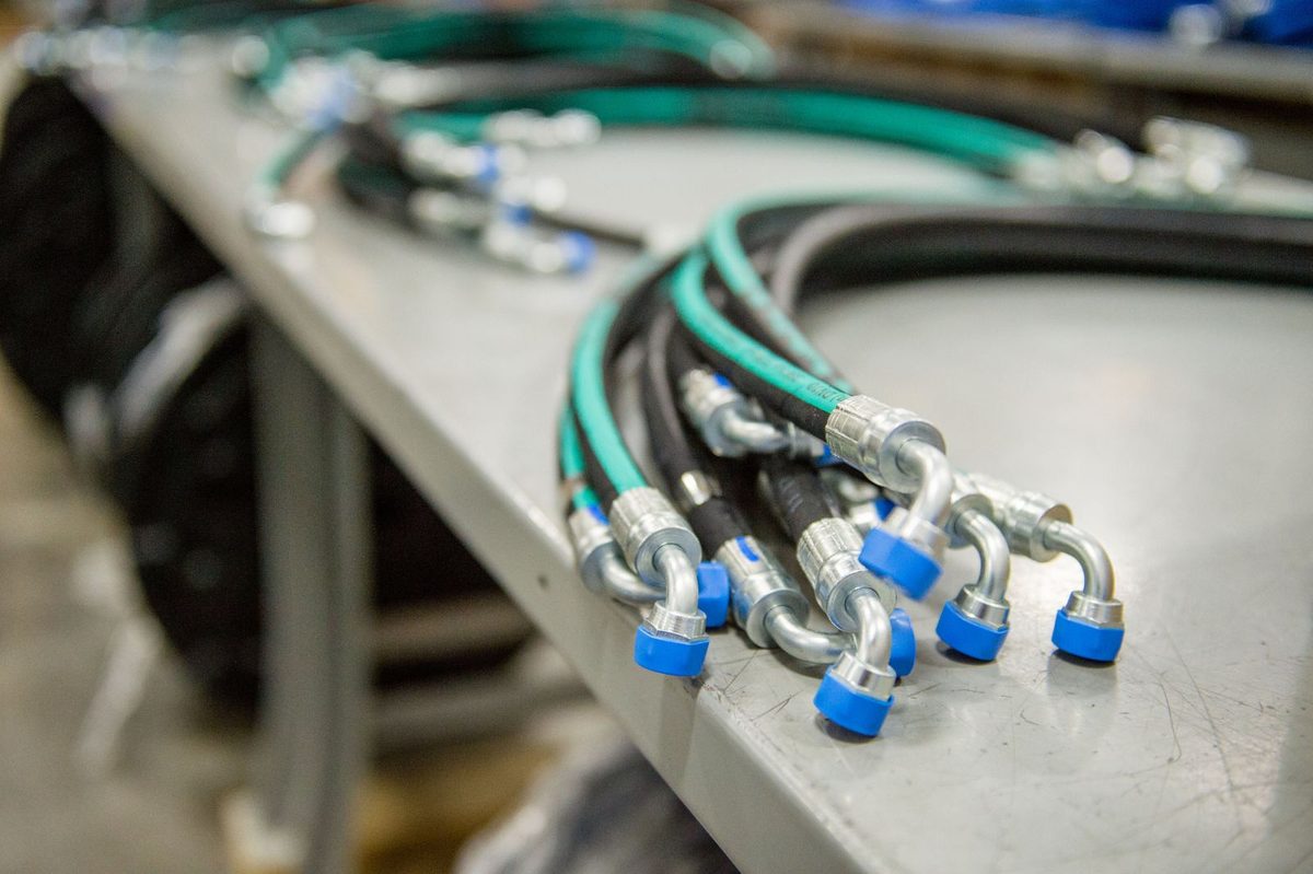 Completed hydraulic hose assemblies with crimped end fittings, staged for kit configuration